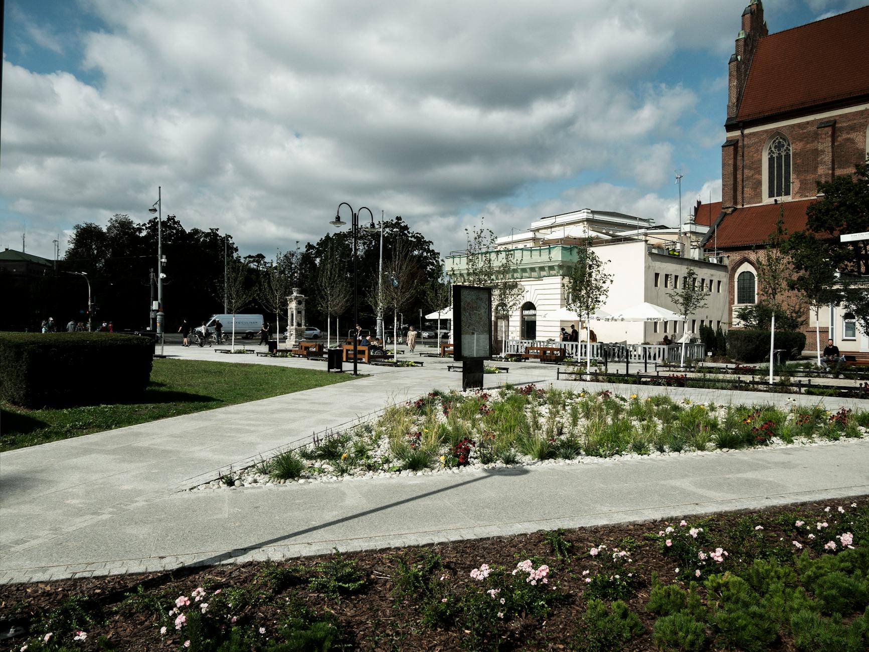Ulica Wrocławska w Łęknicy z historycznymi kamienicami i współczesnymi elementami miejskimi.